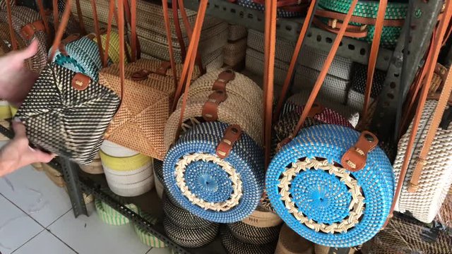 Woman choosing rattan eco bags in the art shop on Bali island, Indonesia. Woman stylish eco bag.