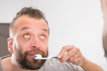 Man brushing his teeth in bathroom