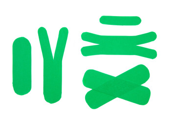 Set of diffrent shape and size green sport elastic kinesio therapeutic tape, also called kinesiology tape strips isolated on white background. Flat lay top view.
