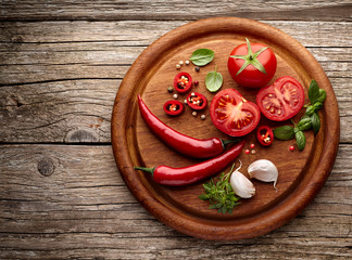 Fototapeta na wymiar fresh tomatoes with pepper, garlic and basil on wooden background