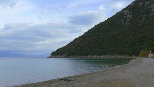 Detail of a flying rising drone on Divna beach. Cres Island. Croatia. Flat plane. Slow motion