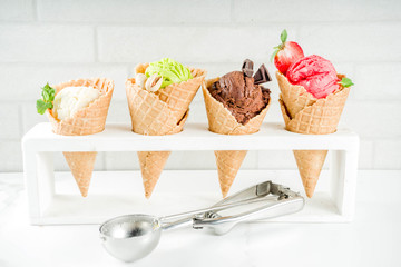 Colorful fruit and berry, nut, chocolate and vanilla ice cream, with waffle ice-cream cones, with fresh fruit and berries, top view copy space white marble background