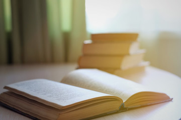 Book stack on wood desk, selective focus