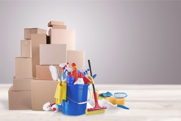 Cleaning supplies with moving boxes on background