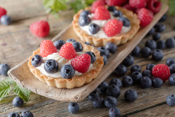  Dessert tarts with raspberries and blueberries .