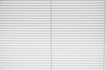 Window with closed metallic blinds, view from inside