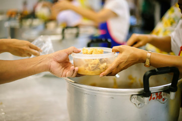 The poor people bring a container to scoop food to eat and relieve hunger and bring home.