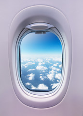 Airplane interior with window view of clouds.