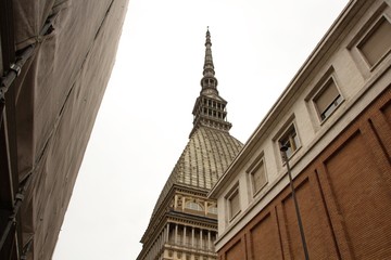 Mole Antonelliana tower in Turin (Torino) town. Rainy, cloudy weather. Tower view from below. Beautiful geometric building. Geometry in buildings. Architecture Of Turin, Italy.