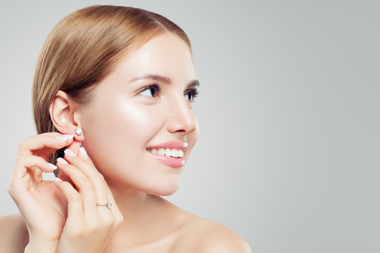 Women earring jewelry model. Cheerful woman with diamond earrings and ring, beautiful face closeup
