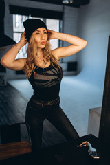 Portrait of a beautiful fashionable woman, blonde, jeans, posing in front of a mirror