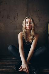 Naklejka premium Portrait of a beautiful fashionable woman, blonde, jeans, brown background