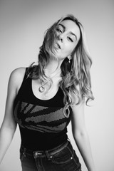 Portrait of a beautiful fashion woman, blonde, jeans, gray background