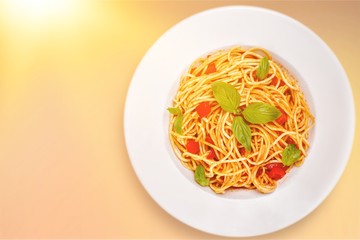 Spaghetti pasta with tomatoes and parsley on  table.
