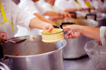 The hands of the hungry get food from the hands of volunteers : concept of hunger poverty