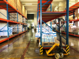 Blurry shelves in the warehouse background.
