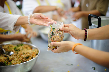 Hands holding food: Hunger problems are assisted by people in society.