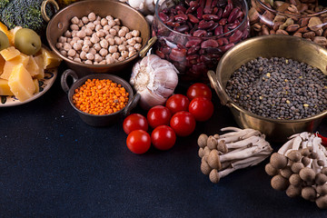Still life food set  on dark background. Concept healthy eating. Broccoli, beans, lentils, nut, cheese, garlic, mushrooms shimidzhi, cherry tomato.