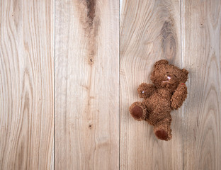 small teddy bear on a wooden background of oak boards