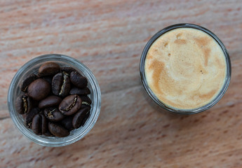 Cups of coffee, one with espresso, one with coffee beans