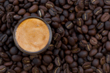 Cup of coffee surrounded with coffee beans