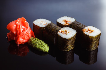 Sushi rolls Maki with eel  on a black background. Traditional Japanese cuisine