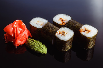 Sushi rolls Maki with eel  on a black background. Traditional Japanese cuisine