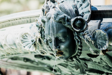 Détail d'une fontaine, sculpture visage de femme