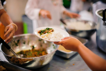 Poor people bring containers to contain food from the sharing of the rich.