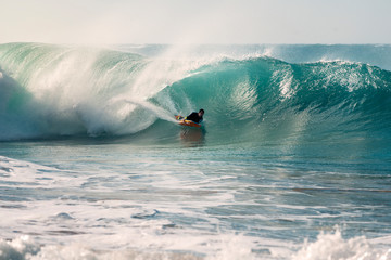 surfer riding the tube of a wave with a bodyboard