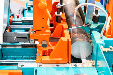 Round shaft steel is being cutting by automatic continuous and high speed horizontal band saw machine for industrial with the coolant fluid
