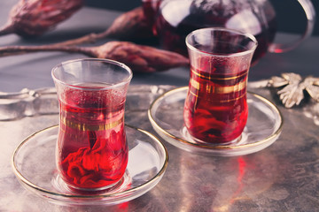 Cups of hot red karkade tea with teapot on the tray