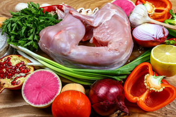 Raw rabbit meat with herbs and spices on a wooden background. top view and blank place