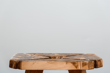Empty rough wooden table top of old stool in blur on a gray background. Side cut close-up. Photo with for copy space.
