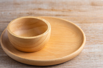 Plate and bowl made from wood on the table.