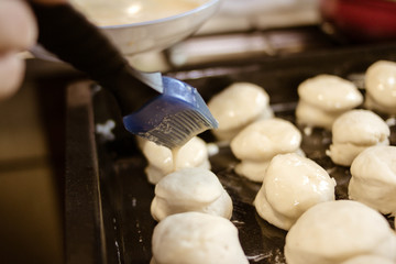 Brushing with a brush and egg on a dough.Selective focus.