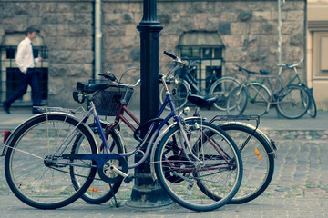 Naklejka na ściany i meble Bicycles are parked to the post in Old Riga