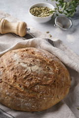 Homemade whole grain bread with seeds on a gray background.