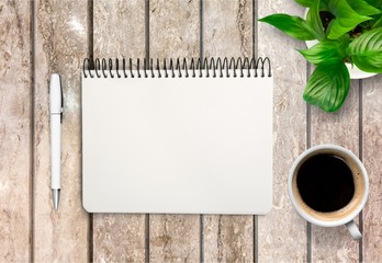 Coffee, notepad and pen on wooden background