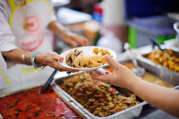 Volunteers serving food for poor people : Food sharing concept - Powered by Adobe