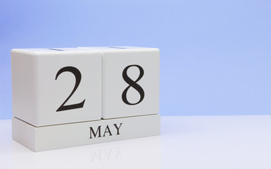 May 28st. Day 28 of month, daily calendar on white table with reflection, with light blue background. Spring time, empty space for text