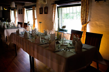 Fully set table at a restaurant with wedding decoration