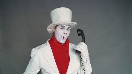 Mime calls by phone. Mime with an old pipe. boy-mime with the phone. Human emotions. Clown talking...