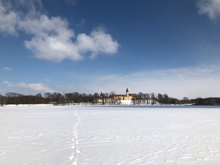 Fototapeta premium Nesvizh Castle, Belarus in winter as seen from across the frozen pond