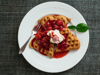 Heart shaped vegan beet waffles with a raspberry sauce. 