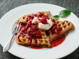 Heart shaped vegan beet waffles with a raspberry sauce. 