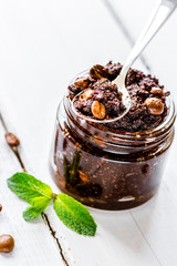 Homemade cosmetics with scrub and coffee beans on desk background