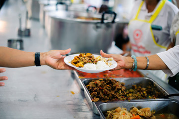 Poor people receiving food from volunteer : The concept of food donation