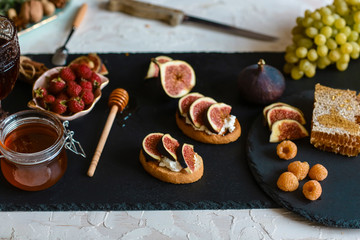 Obraz na płótnie Canvas bruschetta with goat cheese, figs, close up on the stone plate. Flat lay. Top view