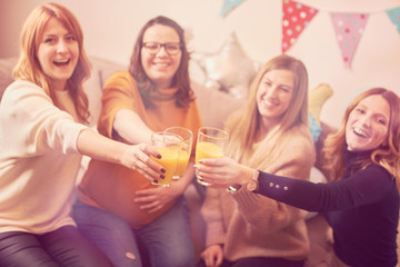 Pregnant woman celebrating baby shower party with friends.